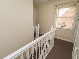 A hallway with a stair railing and a window at Sugar Sands in Longhoughton