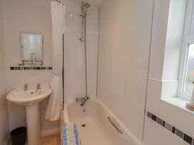 A bathroom with a bathtub and sink at Sugar Sands in Longhoughton