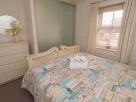 A bedroom with a bed, dresser, and towels at Sugar Sands in Longhoughton