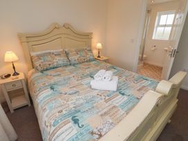 A bedroom with a bed and bathroom view at Sugar Sands Longhoughton