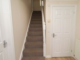 A hallway with stairs and a door at Sugar Sands in Longhoughton