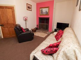 A living room with a sofa and fireplace at Wayside Cottage in Newton-by-the-Sea
