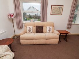 A living room with a sofa and a lamp at Wayside Cottage in Newton-by-the-Sea