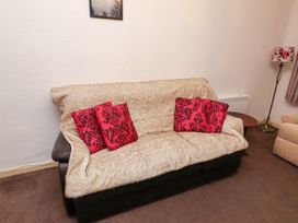 A living room with a sofa and a lamp at Wayside Cottage in Newton-by-the-Sea