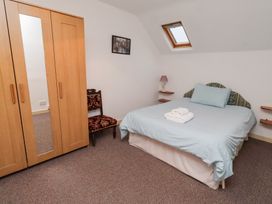 A bedroom with a bed and wardrobe at Wayside Cottage in Newton-by-the-Sea