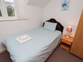 A bedroom with a single bed and bedside table at Wayside Cottage in Newton-by-the-Sea