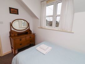 A bedroom with a bed and dresser at Wayside Cottage in Newton-by-the-Sea
