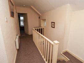 A hallway with staircase and doorways at Wayside Cottage in Newton-by-the-Sea