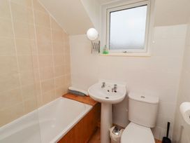 A bathroom with a bathtub, sink, and toilet at Wayside Cottage in Newton-by-the-Sea