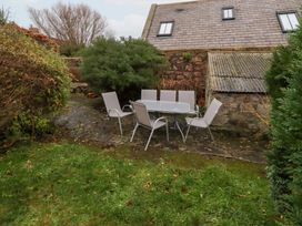 A garden with a table and chairs at Wayside Cottage in Newton-by-the-Sea