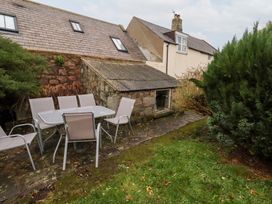 A garden with a table and chairs at Wayside Cottage Newton-by-the-Sea