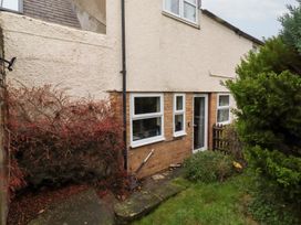 An exterior view of a house with a pathway and plants at Wayside Cottage in Newton-by-the-Sea