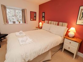 A bedroom with a bed and nightstands at Wynding Down in Bamburgh