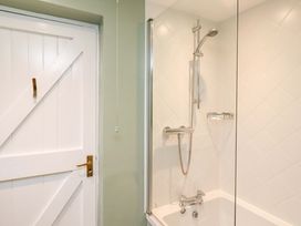 A bathroom featuring a shower and a bath tub at Wynding Down in Bamburgh