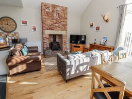 A living room with a fireplace and television at Red Fox in Lucker