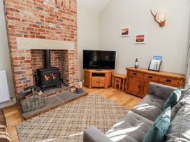 A living room with a fireplace and television at Red Fox in Lucker