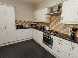 A kitchen with cabinets, oven, and a microwave at Red Fox in Lucker