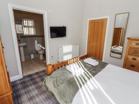 A bedroom featuring a bed, television, and door to bathroom at Red Fox in Lucker