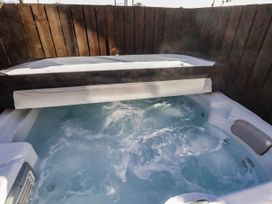 A hot tub with water and cover in an outdoor area at Red Fox in Lucker