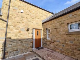 An entryway with a front door and stone walls at Roe Deer in Lucker