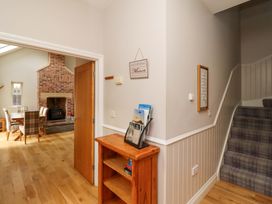 A hallway with bookshelf and staircase at Roe Deer in Lucker