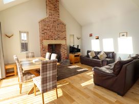 A living room with a fireplace and dining area at Roe Deer in Lucker