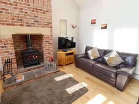 A living room with a fireplace and sofa at Roe Deer in Lucker