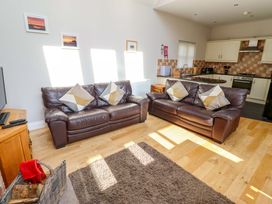 A living room with two sofas and a kitchen area at Roe Deer in Lucker