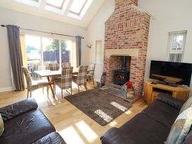A living room with a fireplace and dining area at Roe Deer in Lucker