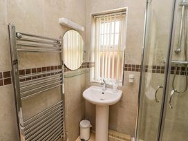 A bathroom with a shower, wash basin, and towel radiator at Roe Deer in Lucker