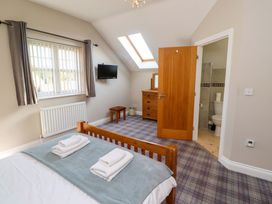 A bedroom with a bed and television at Roe Deer in Lucker