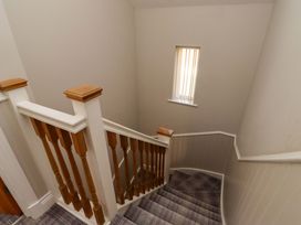 A staircase with wooden railing and window at Roe Deer in Lucker