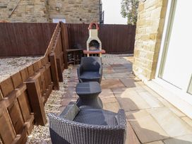 An outdoor area with chairs and a fireplace at Roe Deer in Lucker