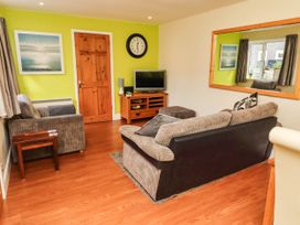 A living room with a sofa and television at Flora Cottage Beadnell