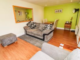 A living room with a sofa and dining area at Flora Cottage Beadnell