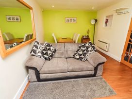 A living room with a sofa and dining table at Flora Cottage in Beadnell