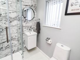 A bathroom with a shower, sink, and toilet at Flora Cottage Beadnell