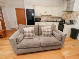 A living room with a sofa and kitchen area at Chiff Chaff in Lucker