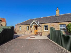 A cottage exterior with garden furniture at Greenfinch in Lucker