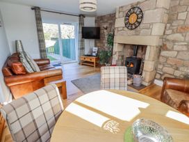A living room with a fireplace and sofa at Greenfinch in Lucker