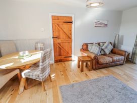 A living room with a sofa and dining table at Greenfinch in Lucker
