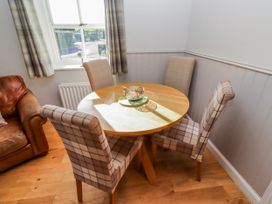 A dining room with a round table and chairs at Greenfinch in Lucker