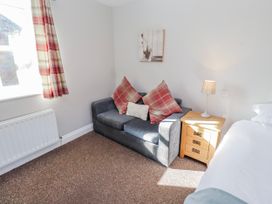 A living room with a sofa and side table at Greenfinch in Lucker