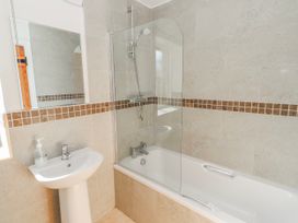 A bathroom with a bathtub and sink at Greenfinch in Lucker