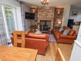 A living room with a fireplace and sofas at Rosefinch in Lucker