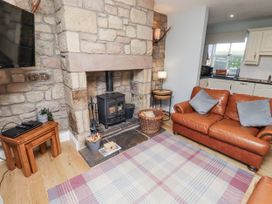 A living room with a fireplace and sofa at Rosefinch in Lucker