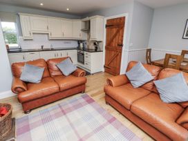 A kitchen with leather sofas and dining area at Rosefinch in Lucker