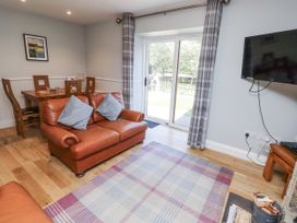 A living room with a sofa and dining area at Rosefinch Lucker