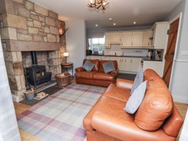 A living room with a fireplace and two sofas at Rosefinch in Lucker