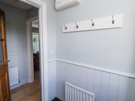 A hallway with wall hooks and radiator at Rosefinch in Lucker